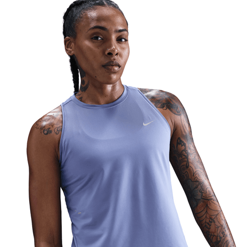 Woman wearing a light blue tank top with a Nike logo on a white background