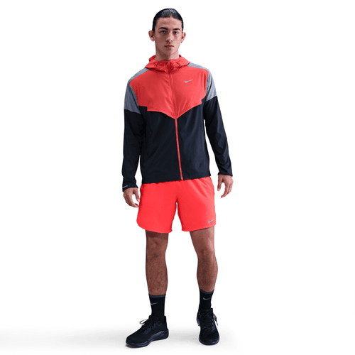 Person wearing a red and black athletic outfit on a white background