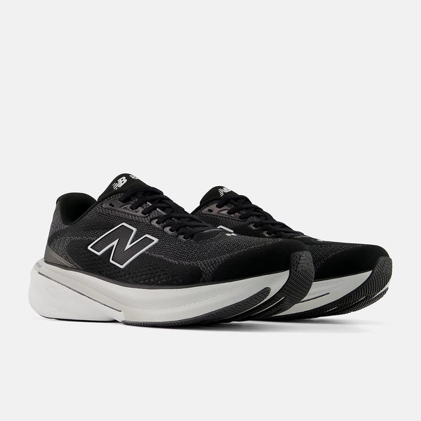 Black running shoes with white soles on a light gray background
