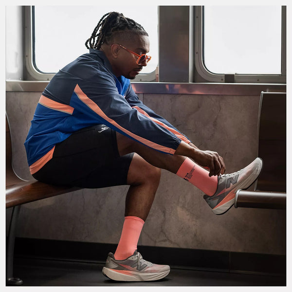 Person sitting on a ferry bench tying their shoe.
