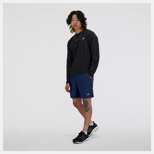 Person wearing a black long-sleeve shirt and blue shorts with a brand logo on a light gray background