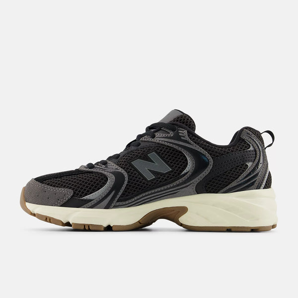 Black sneaker with a white sole on a light gray background