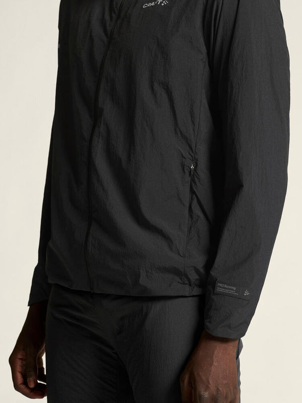 Black jacket worn by a person on a beige background