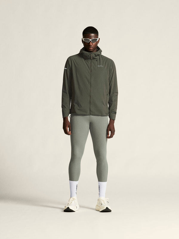 Person wearing a green jacket and leggings on a plain background