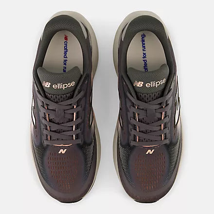 A pair of New Balance running shoes in dark brown and black with a white midsole and subtle pink accents, shown against a light gray background.