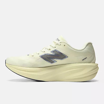 A New Balance running shoe in a pale cream-yellow colorway, featuring a textured mesh upper, matching laces, a thick sculpted foam midsole, and a metallic silver 'N' logo on the side.