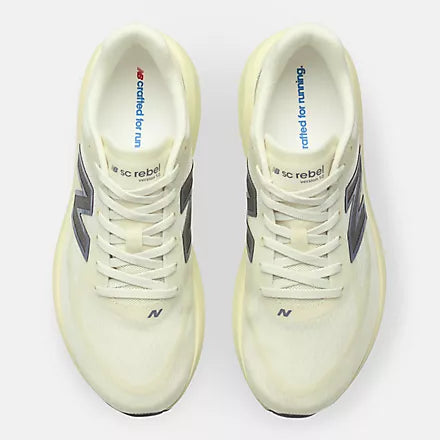 A New Balance running shoe in a pale cream-yellow colorway, featuring a textured mesh upper, matching laces, a thick sculpted foam midsole, and a metallic silver 'N' logo on the side.
