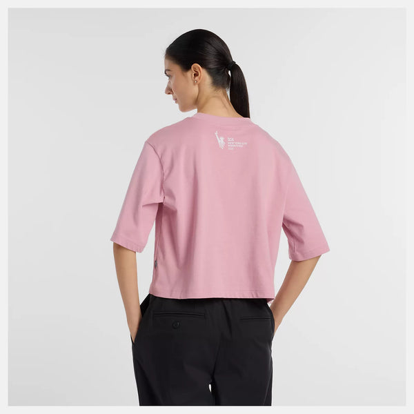 Person wearing a pink t-shirt with a logo on the back against a white background