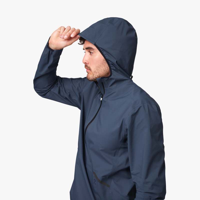 Side view (with hood) of a male model wearing the Men's Waterproof Anorak by ON in the color Navy