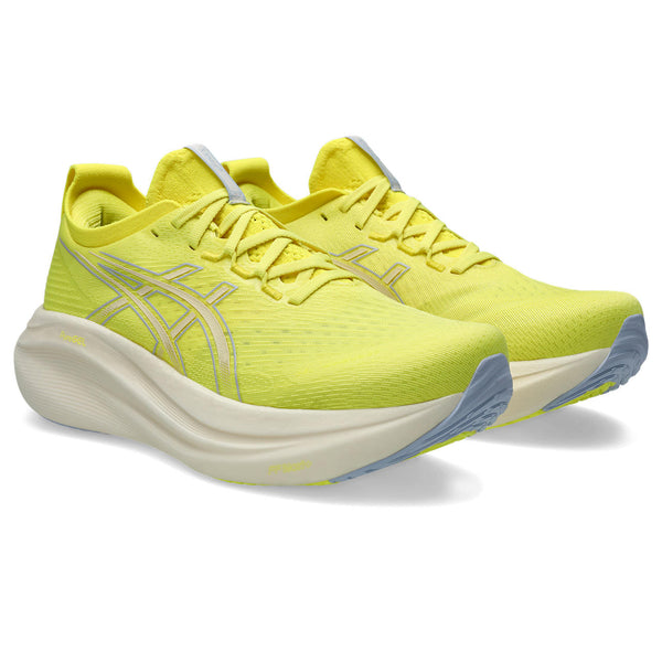 Pair of bright yellow running shoes with a white sole on a white background