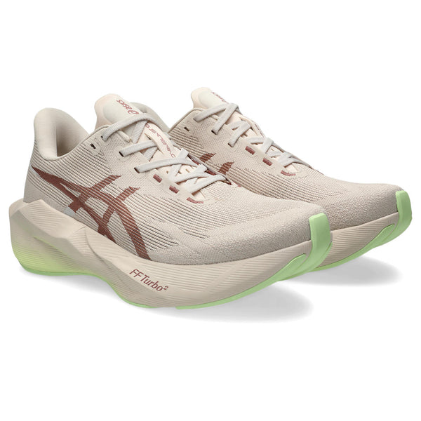 Beige running shoes with green accents on a white background