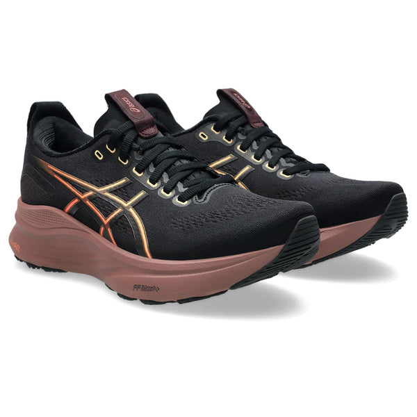 A pair of wmoen's ASICS kayano 32 with a mostly black upper and a dark midsole.