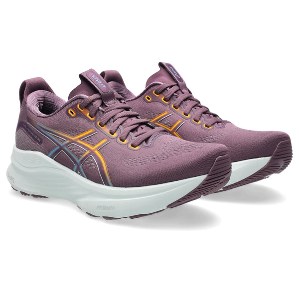 Pair of purple running shoes with white soles on a white background