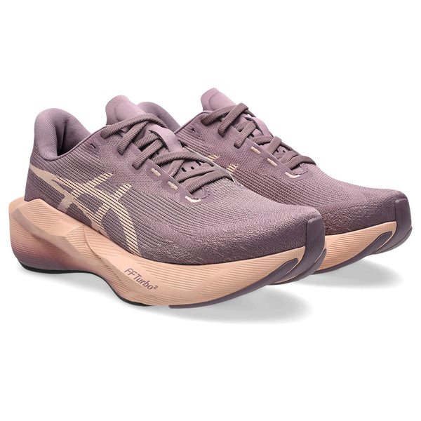Pair of purple running shoes with beige soles on a white background