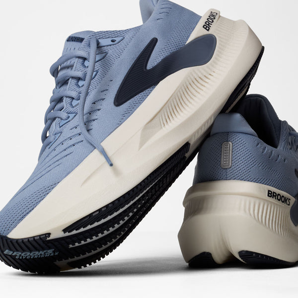 Blue and white running shoes with 'Brooks' branding on a light gray background