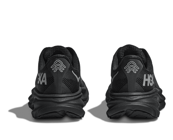 The Hoka logo and Hoka brand name are stitched onto the lateral and medial sides of the upper using grey thread. 