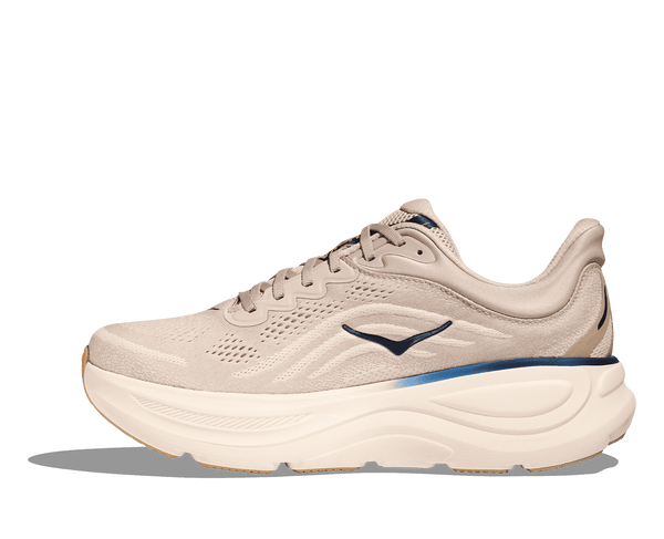 Beige running shoe with blue accents on a green background