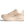 Medial side of a beige running shoe on a transparent background.