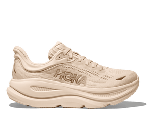 Beige running shoe with Hoka branding on a transparent background.