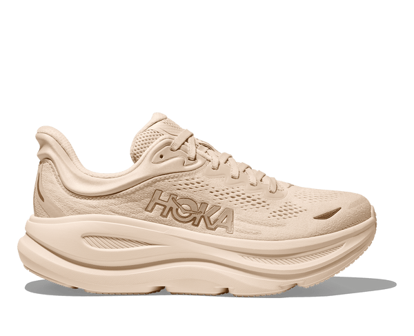 Beige running shoe with Hoka branding on a transparent background.