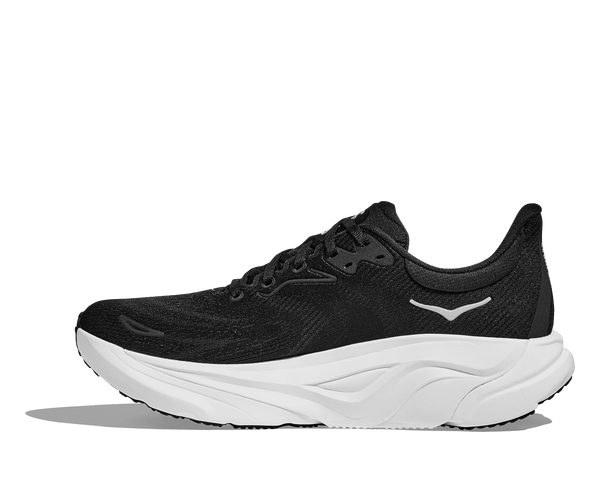 The Hoka logo is stitched near the ankle on the medial side of the upper. 