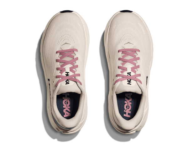 White running shoes with pink laces and Hoka branding on a transparent background