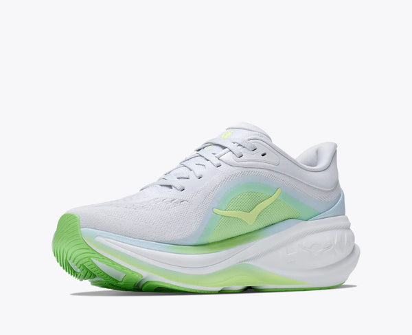 White running shoe with green sole on a white background