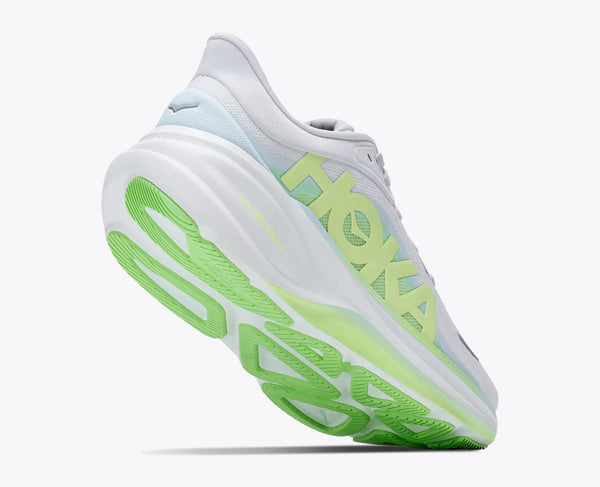 White running shoe with green sole on a white background