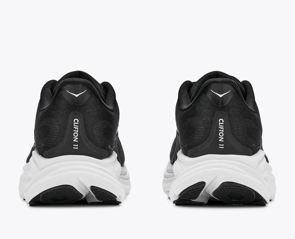 Black running shoes with white soles on a white background