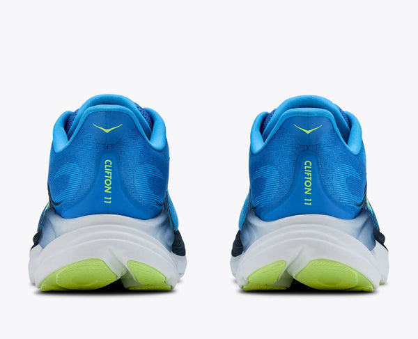 Blue running shoes with green soles on a white background