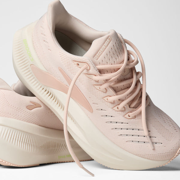 A pair of Brooks Adrenaline GTS running shoes in a light blush pink and cream colorway, displayed on a clean light gray background.