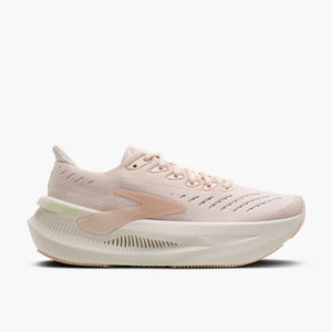 A single running shoe in a light blush pink and cream colorway, shown from a side profile against a clean white background. The shoe features a knit upper, a thick cushioned midsole, and a distinctive side logo.