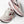 Pair of white and pink running shoes with 'Brooks' branding on a light background