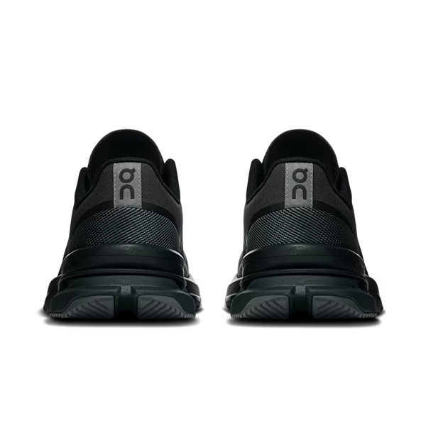 A pair of black On gym shoes shown from the back, featuring a textured mesh upper, a gray heel tab with the On logo, and thick black midsoles, set against a plain white background.