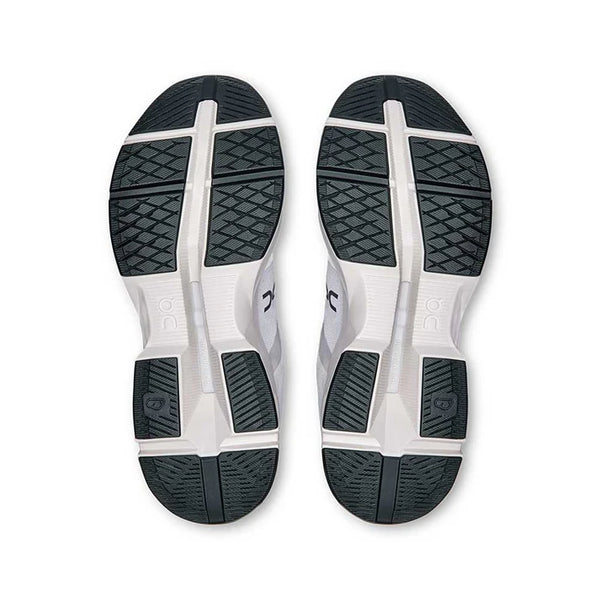 Top view of a pair of white athletic shoes with black soles on a white background.