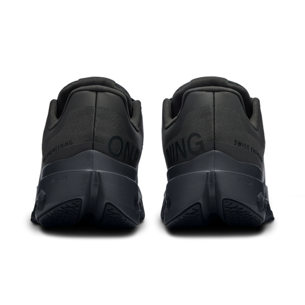 Black athletic shoes with branding on the sole against a white background