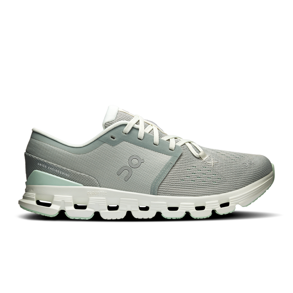 Green running shoe with white sole on a white background