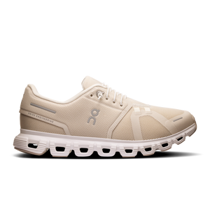 A pair of women's running shoes in beige color with a flexible white sole.