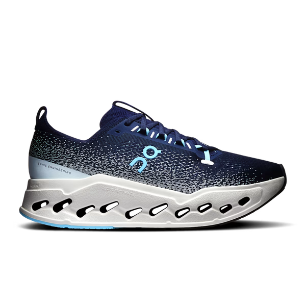 On running shoe in navy blue with a speckled pattern, a light blue On logo, and a white sculpted sole with black cutouts, shown against a plain white background.
