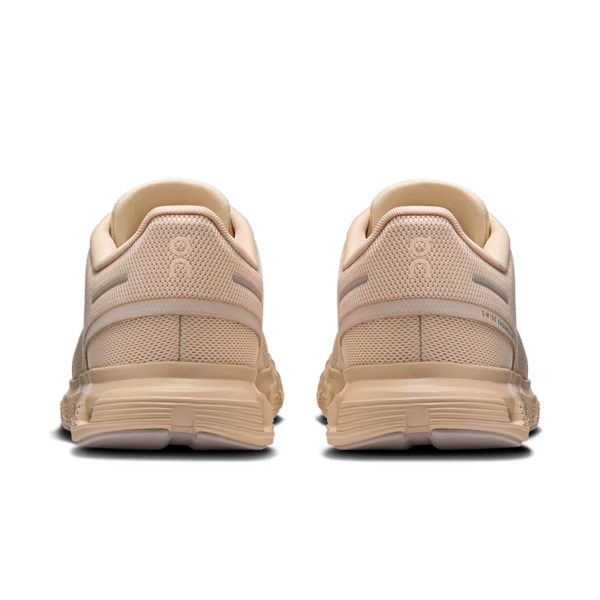 Pair of beige running shoes on a white background
