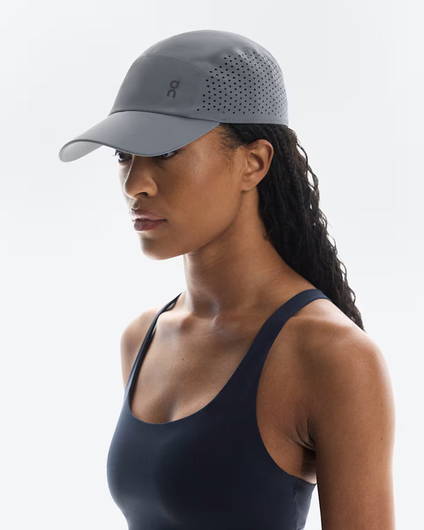 Woman wearing a gray cap with a brand logo on a white background