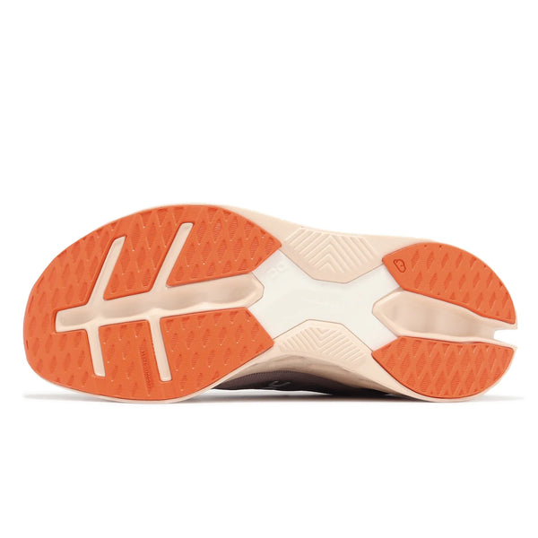 Close-up of a shoe sole with orange tread pattern on a white background.