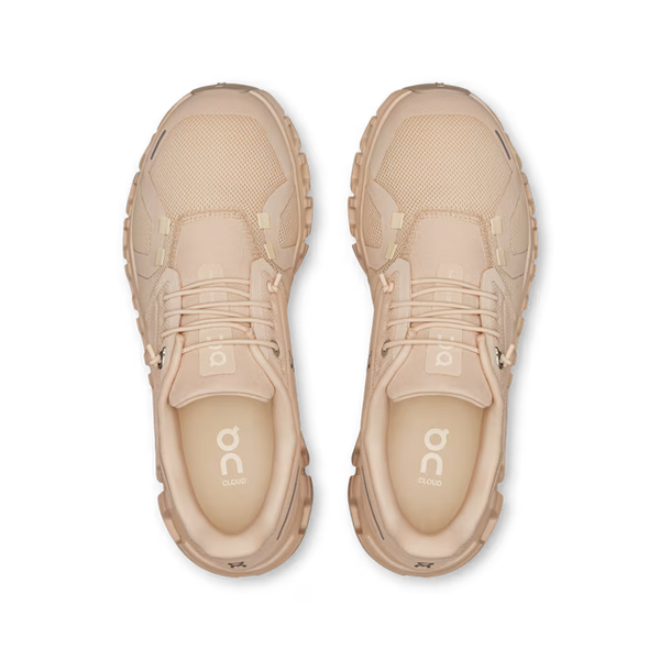 Pair of beige athletic shoes with 'on' logo on a white background