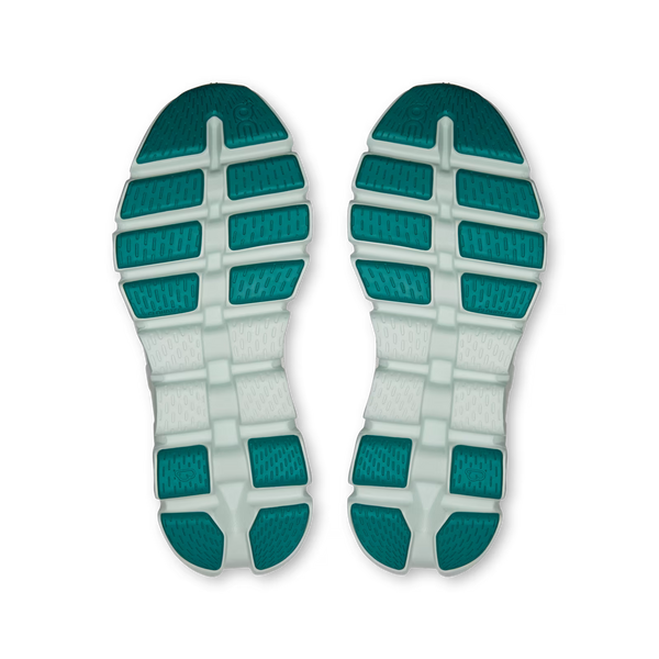 A pair of athletic shoe soles shown from above, featuring a dual-tone design with teal green textured rubber blocks and a white textured midsole.