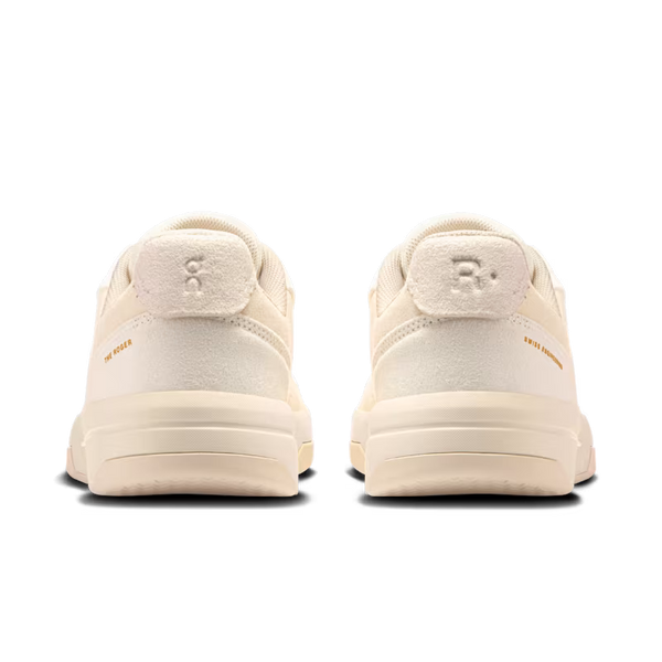 A pair of cream-colored sneakers shown from the back, featuring a thick platform sole and a textured heel tab with a debossed logo.
