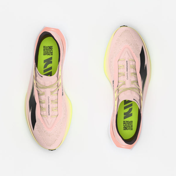 Pink running shoes with green sole on a white background