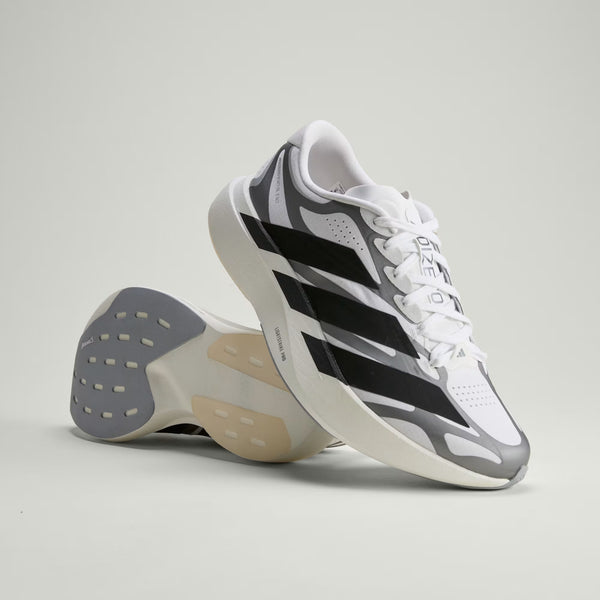 White Adidas sneaker with black stripes on a light gray background