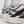 Close-up of a sneaker with black and gray design on a light background