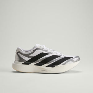 White sneaker with black and gray stripes on a light gray background