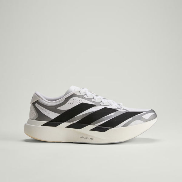 White sneaker with black and gray stripes on a light gray background